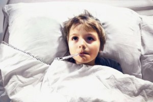 Kind liegt mit Fieber im Bett